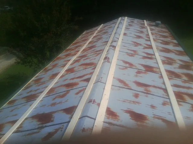 Rusted metal roof panels with new wood purlins before replacement — Storm Damage Roof Repair in Clitherall by Roofing Brothers
