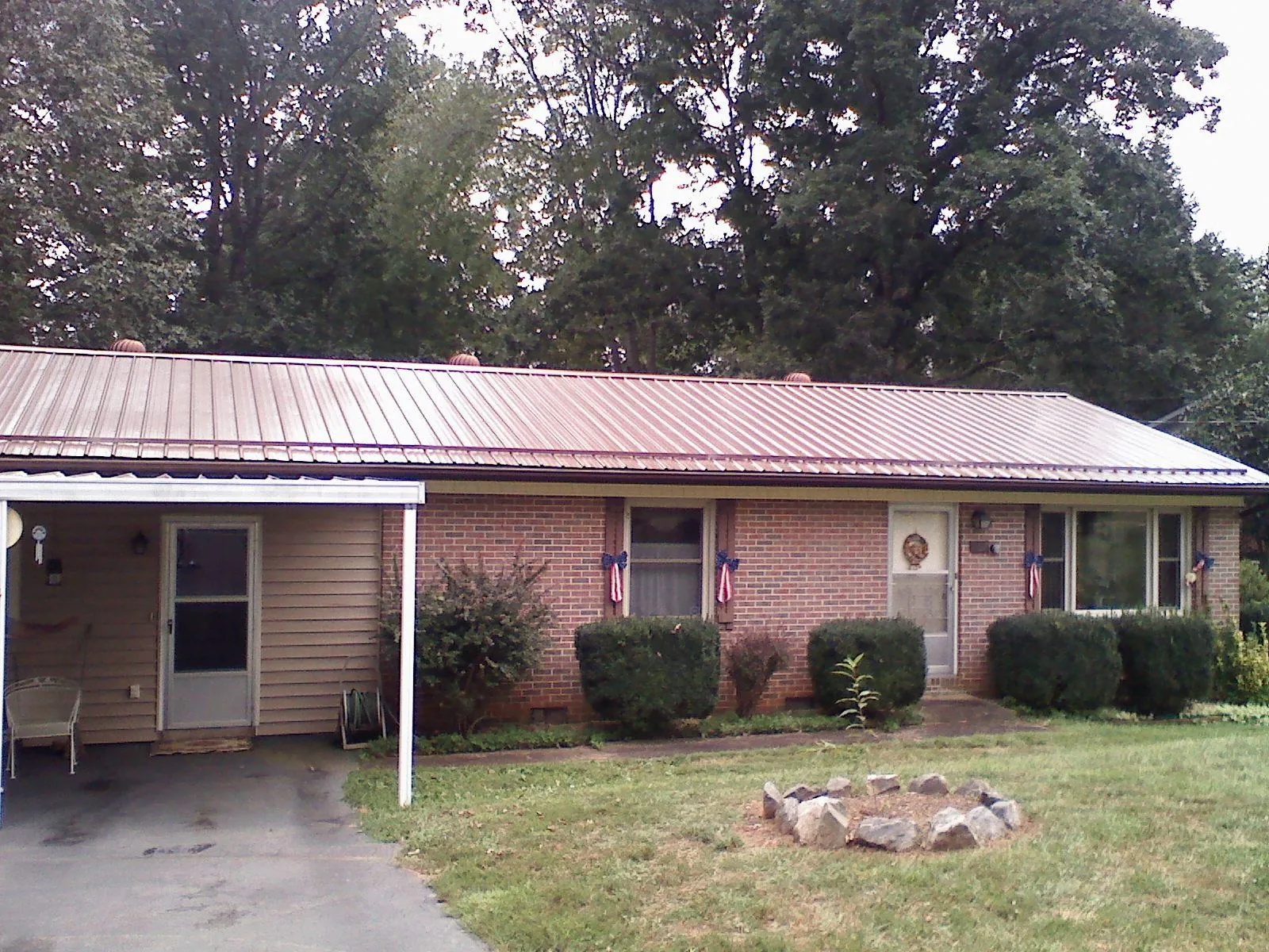 Bronze metal roof and carport on a brick ranch home — Roof Repair work by our crew in Clitherall